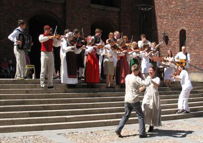 An orchestra playing Swedish folk music with dancers performing traditional folk dances at Stockholm City Hall on National Day 2007 (photo: Peter Isotalo)