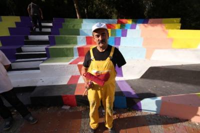 Painter at Abbasağa park painted the brand of his overall before taking a photo
