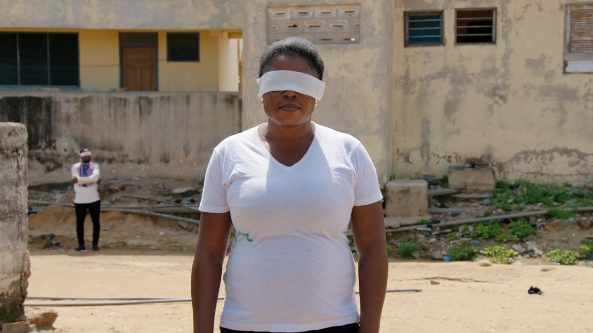 Blindfolded Woman in Accra, Ghana (Filmstill: Contradict, Thomas Burkhalter & Peter Guyer, Switzerland/Ghana 2020)